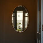 espelho colocado na entrada da casa refletindo o ambiente interno com luz natural