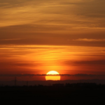 Pôr do sol no horizonte com cores quentes transmitindo sensação de encerramento e tranquilidade.