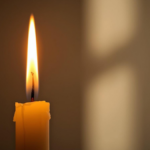 Chama de vela alta e pontuda acesa iluminando ambiente tranquilo
